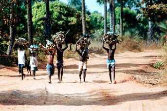 Poor african workers carrying wood